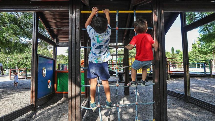 Dos niños juegan en un parque de València, ayer, horas antes de que se cierren las 664 áreas infantiles de la ciudad.