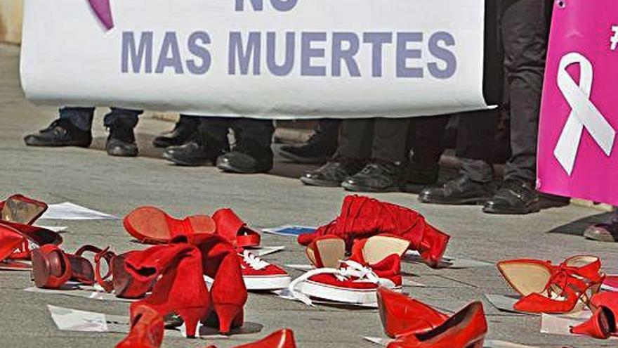 Zapatos de tacón esparcidos por el suelo durante una concentración contra la violencia machista.