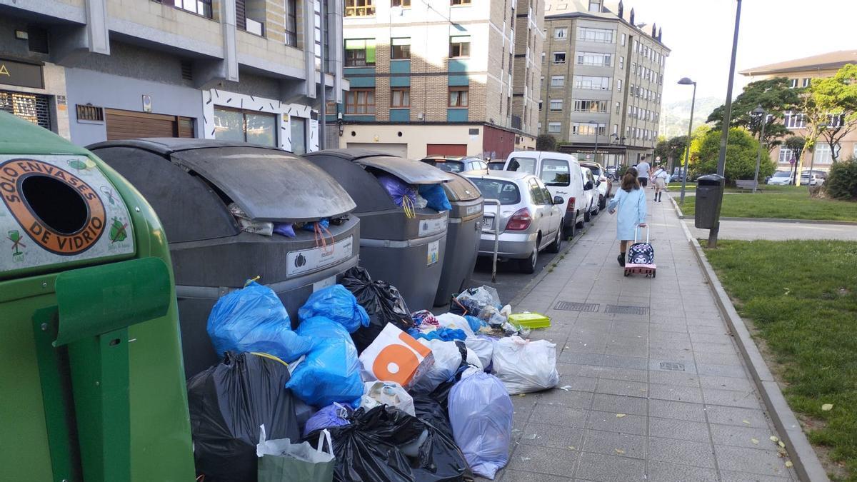 Bolsas de basura acumuladas junto a unos contenedores en La Felguera a finales de mayo.