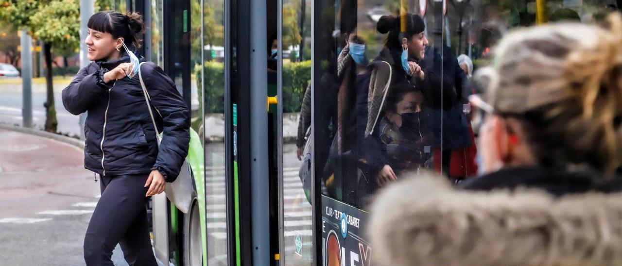 Una usuaria de Aucorsa se desprende de la mascarilla, al salir del autobús.