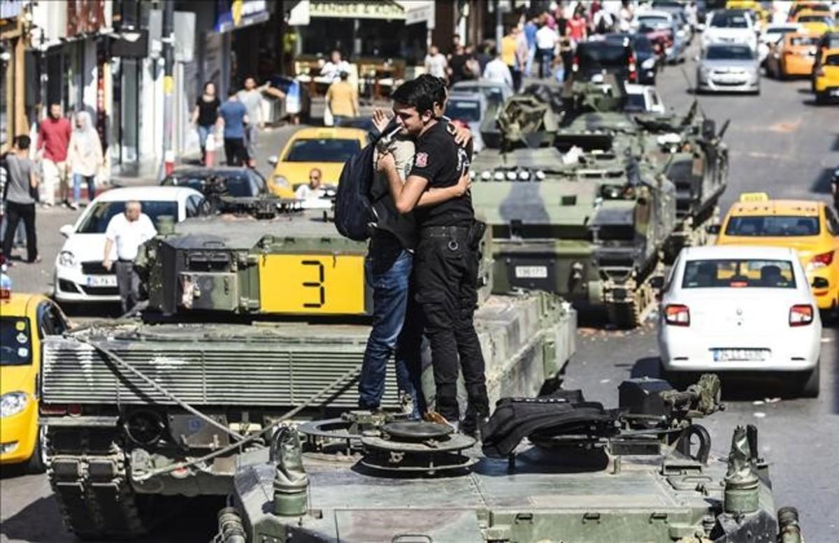 Un hombre se abraza a un policia sobre un tanque, en Uskudar (Istanbul)