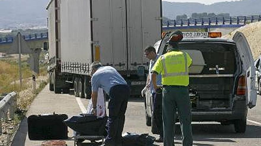 Una mujer de 57 años ha fallecido en un accidente de tráfico al colisionar un turismo con un camión a la altura de la localidad valenciana de Albaida. En la imagen, unos operarios del servicio judicial recogen el cuerpo sin vida de la mujer.