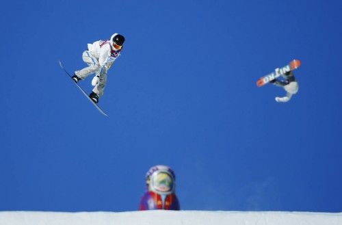 Snowboarders sail off jumps during snowboard slopestyle training at the 2014 Sochi Winter Olympics in Rosa Khutor