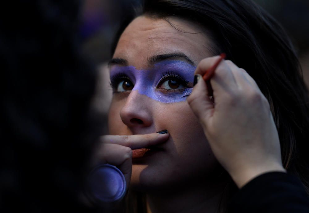 A woman applies make-up to another woman during ...