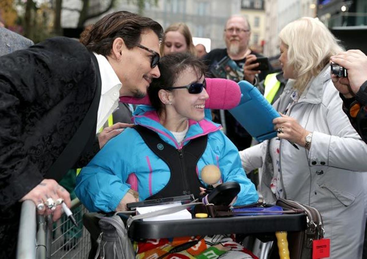 Johnny Depp posa junto a una fan, en la première europea de Alicia, a través del espejo.