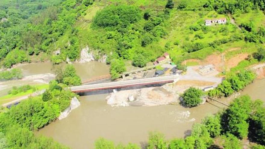 el «tapón» de palomar. La imagen muestra el estado que presentaba ayer la zona en la que se ejecuta el nuevo paso sobre el Nalón. Los vecinos de Bueño aseguran que la escollera construida para facilitar los trabajos «taponó» el paso del río y agravó el desbordamiento.