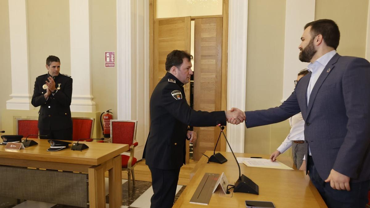 El alcalde le da la enhorabuena al nuevo inspector de la policía local.