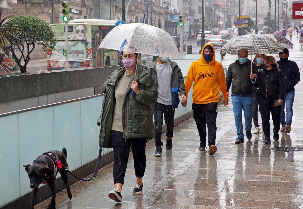 Los viandantes en el centro de Vigo se pertrecharon con paraguas