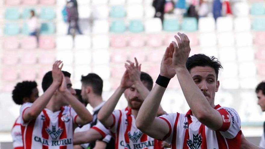 Javi Bueno, Levas y Adrián aplauden a la afición tras el partido del domingo.