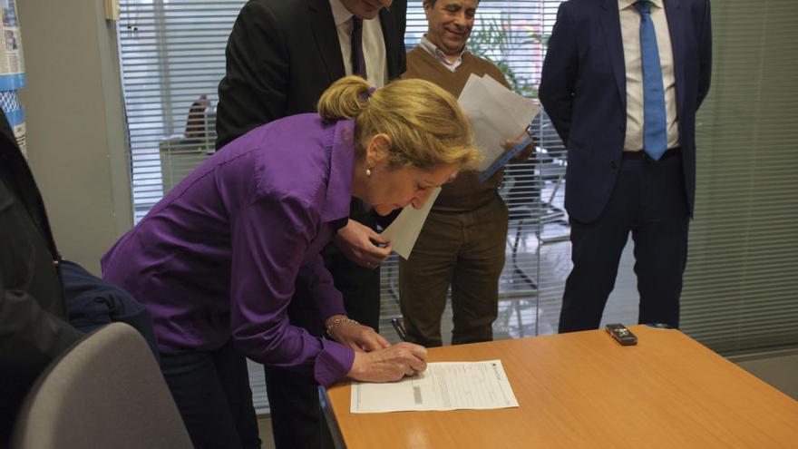 La representante de AFIBE firma la recepción de la ayuda de La Caixa.