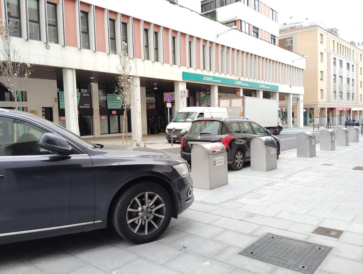 Un coche sobre la acera y otro detenido en el carril de circulación.