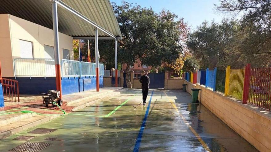 Un operario limpia un colegio del municipio.