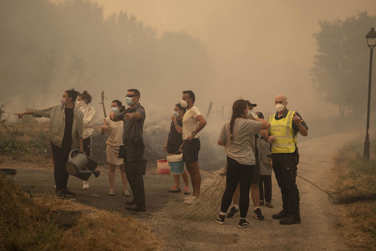 Vecinos trabajan en labores de extinción del incendio forestal de Carballeda de Avia (Ourense) este domingo. La ola de incendios que afecta al noroeste de España no da tregua este domingo. Tras una semana de incendios que han causado tres muertos, miles de hectáreas quemadas y miles de desalojados por las llamas, el país se encuentra devastao. En la región de Galicia ardieron ya 50.000 hectáreas y en la de Castilla y León 3.500 personas permanecían fuera de sus hogares. EFE/ Brais Lorenzo