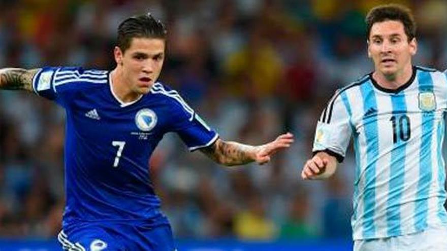 Besic, a la izquierda, disputa un balón con Messi.