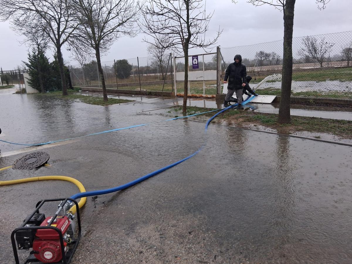 Els veïns redirigint l'aigua que vessa cap a les immediacions del camp de futbol