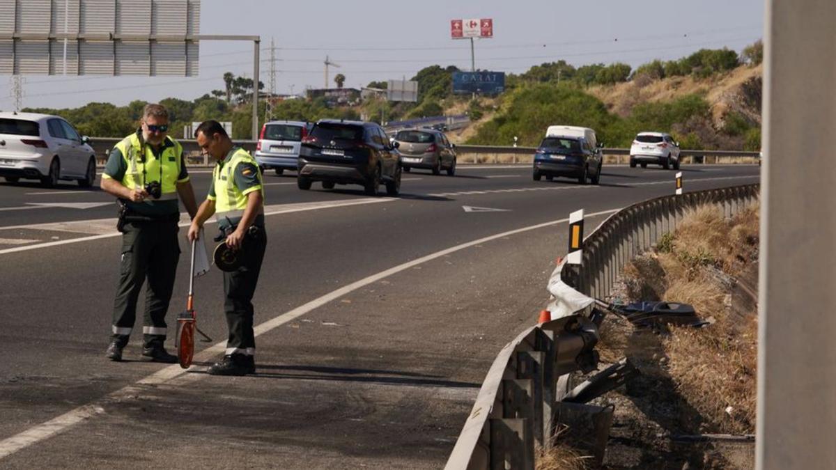 Dos agentes de la Guardia Civil toman datos del accidente.