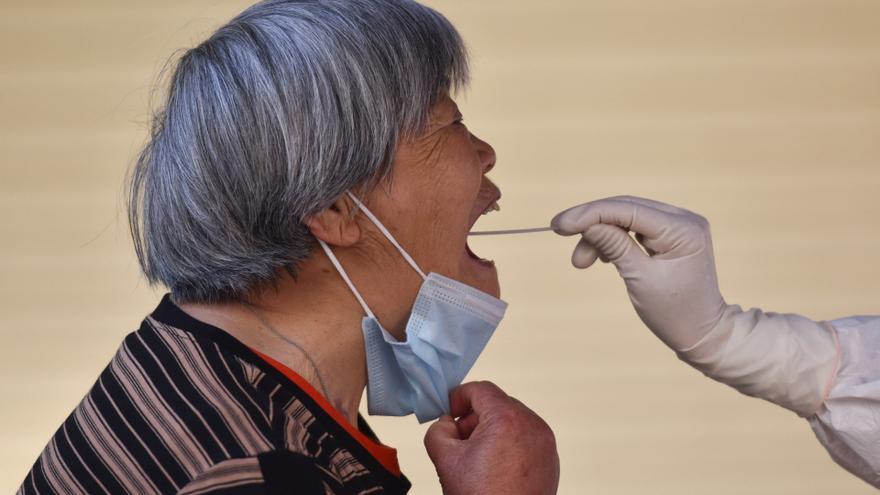 Archivo - 10 April 2022, China, Fuyang: A health worker wearing a Personal Protective Equipment collects swab samples from a resident. Photo: Sheldon Cooper/SOPA Images via ZUMA Press Wire/dpa