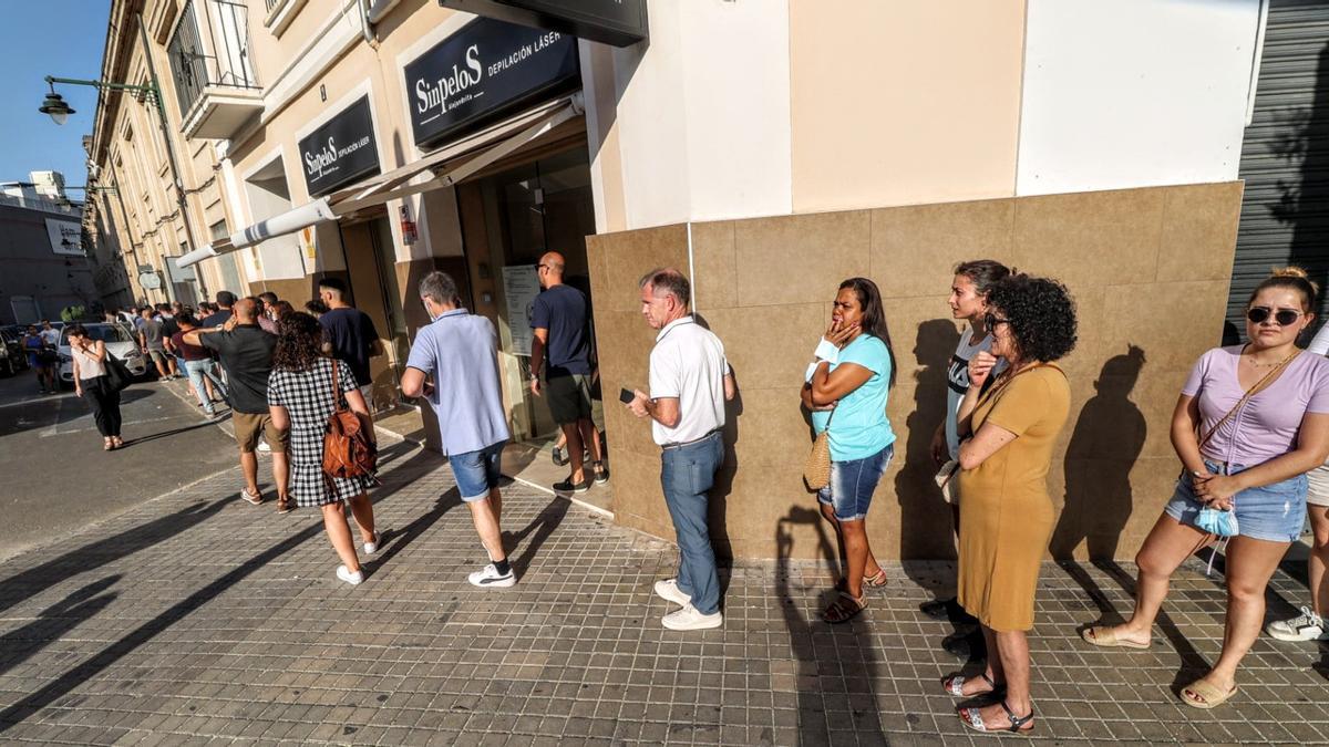 Un grupo de personas espera para vacunarse en el centro de salud.