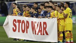 Jugadores del Barça y del Nápoles posan por una pancarta por el final de la guerra antes de su partido de este jueves.