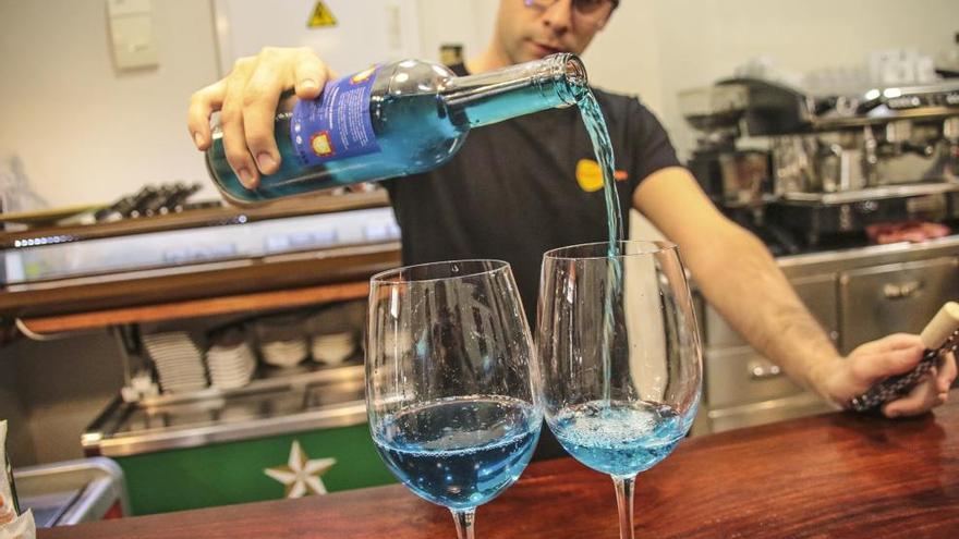 Un camarero sirve dos copas de este caldo azul en una tapería en Orihuela.