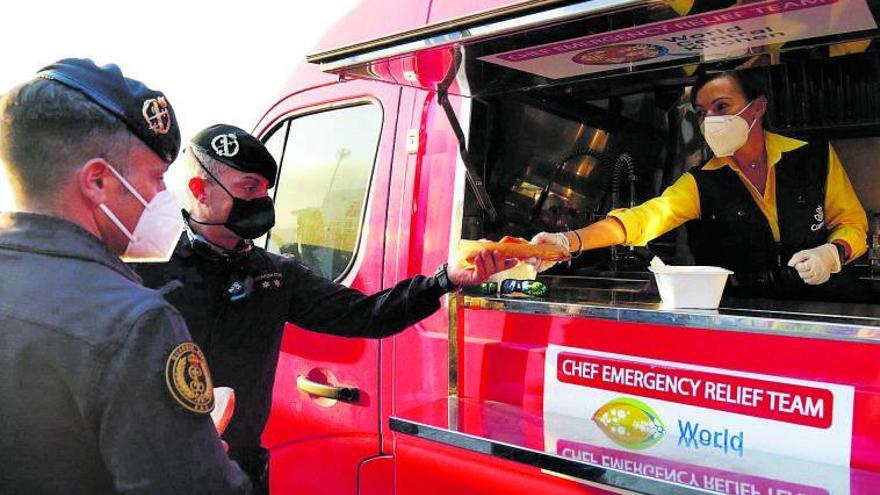 La trabajadora de Correos Nira Sánchez entrega un bocadillo de chorizo a uno de los agentes de la Guardia Civil de Sevilla desplazado al volcán de Tajogaite.