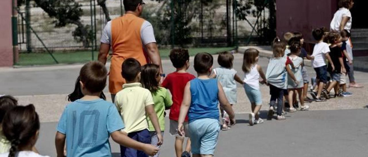 Familias y niños en los accesos a un colegio en un primer día de clase