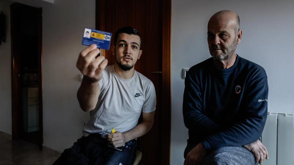 Karim Bouraada, con su padre Mustapha, muestra la tarjeta sanitaria de Melilla, con la que ahora, en Ripoll, se niegan a atenderle.