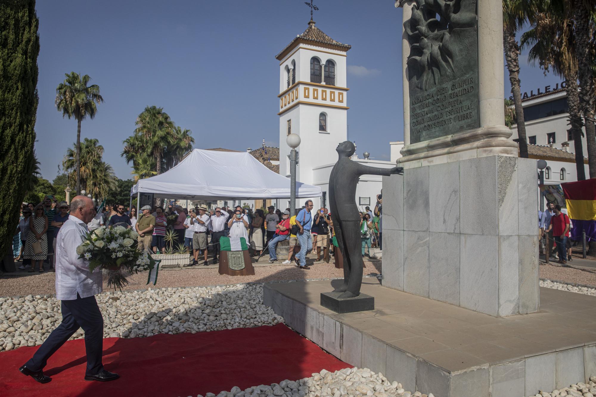 Monumento a Blas Infante rodeado de flores durante el acto por el 86 aniversario del asesinato de Blas Infante.