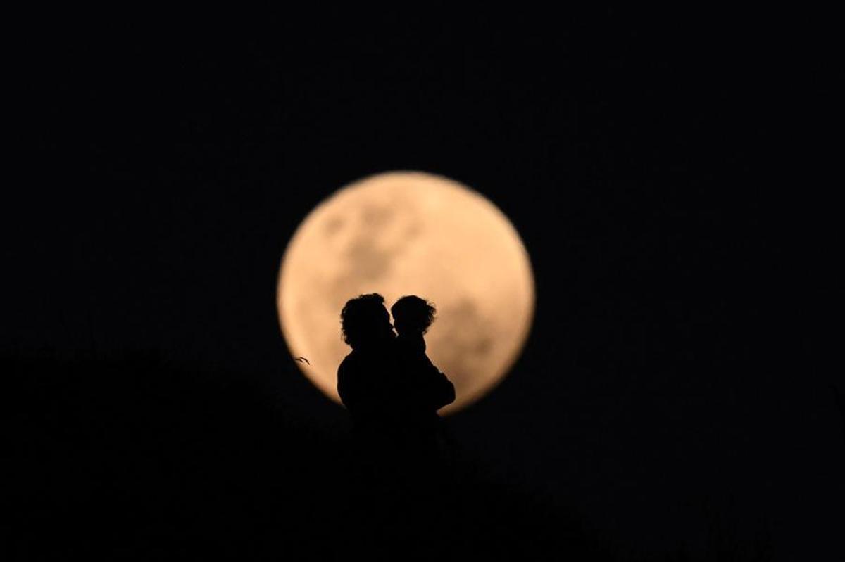 Fotografía de padre e hijo con la luna de fondo.