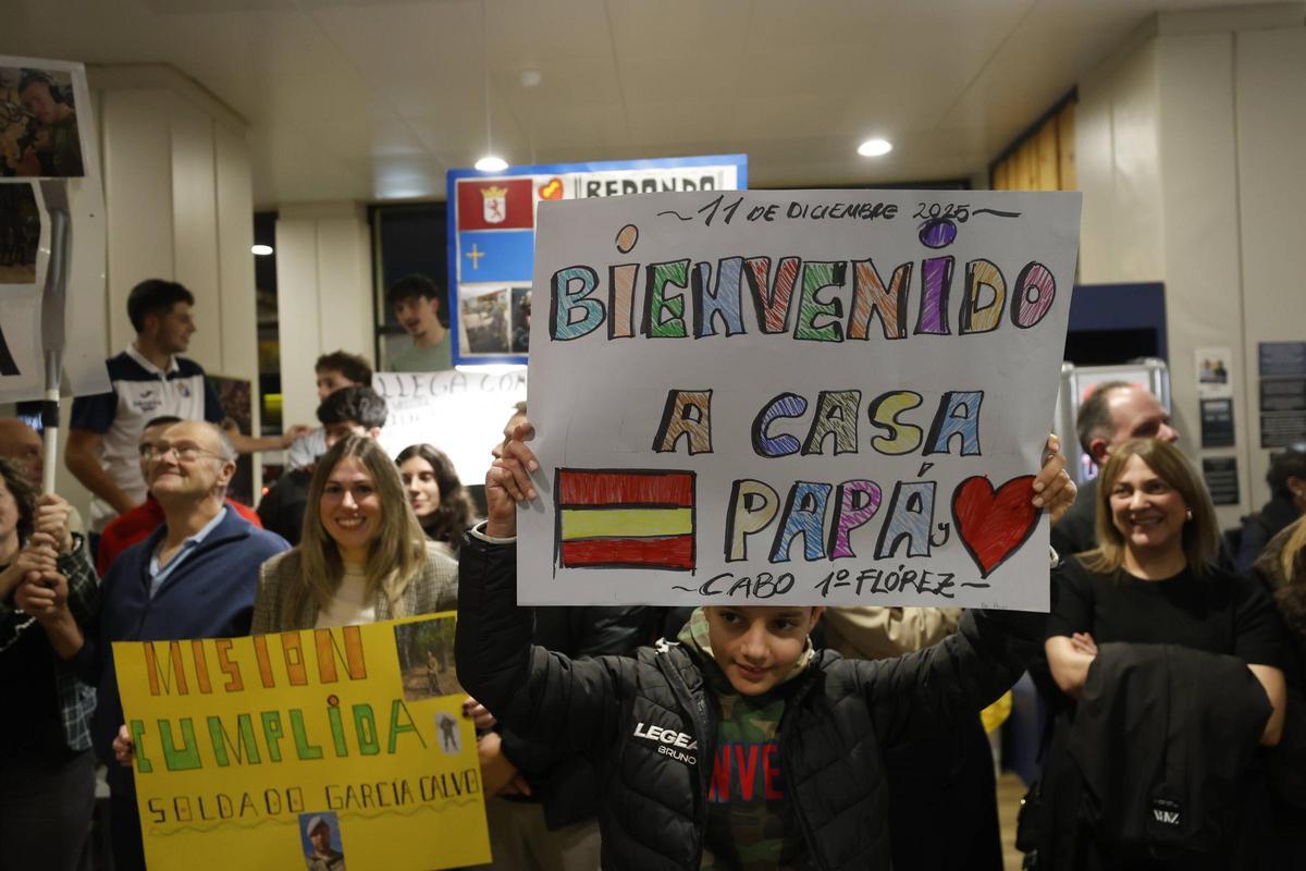 Paula Fernández y Bruno Fernández con carteles de bienvenida a sus seres queridos.