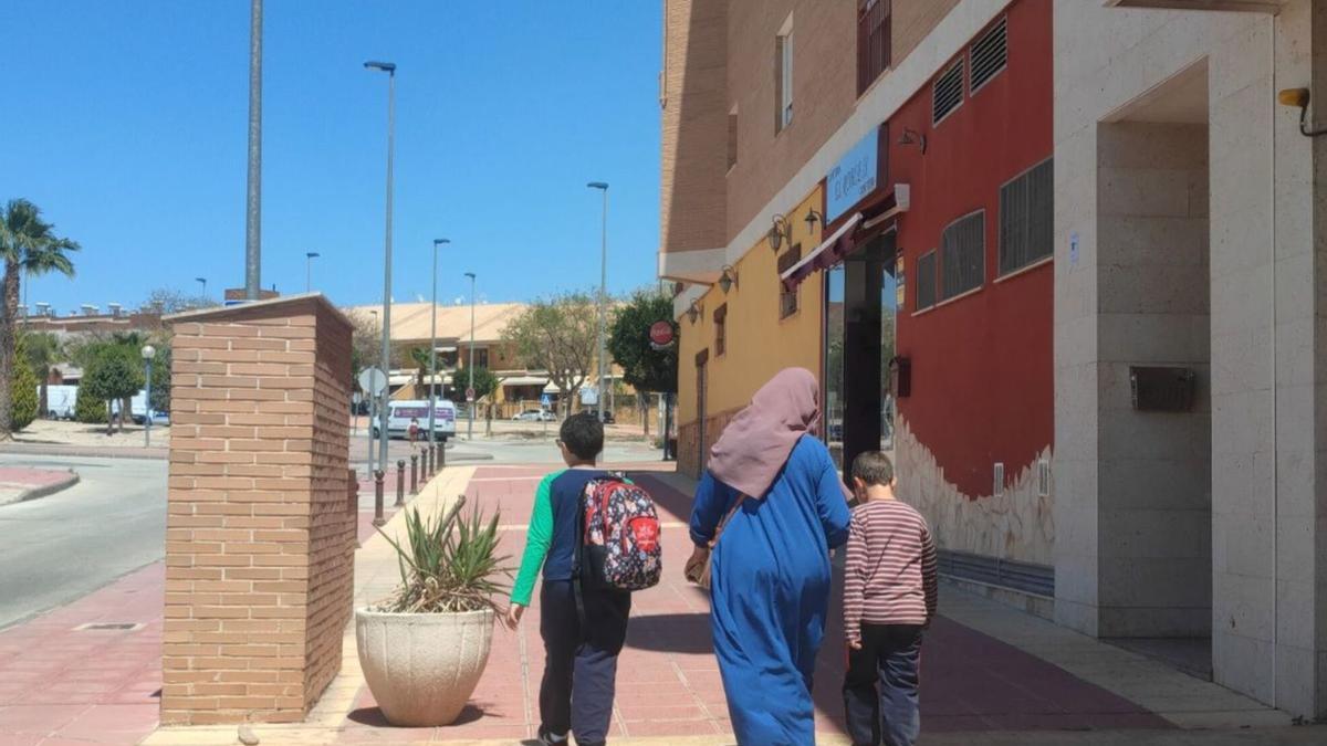 Una mujer camina con dos menores hacia la escuela en una calle del centro de Molina de Segura en una imagen de archivo.