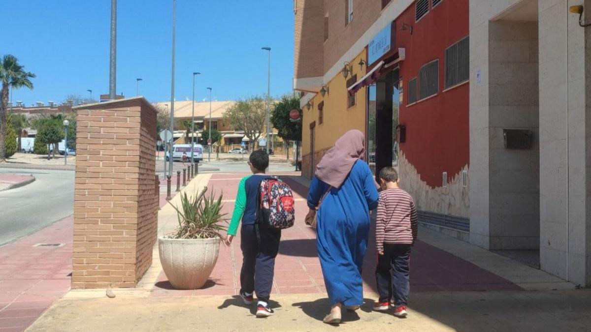 Una mujer musulmana camina con dos menores hacia la escuela en una calle de Molina de Segura.  | L. O.