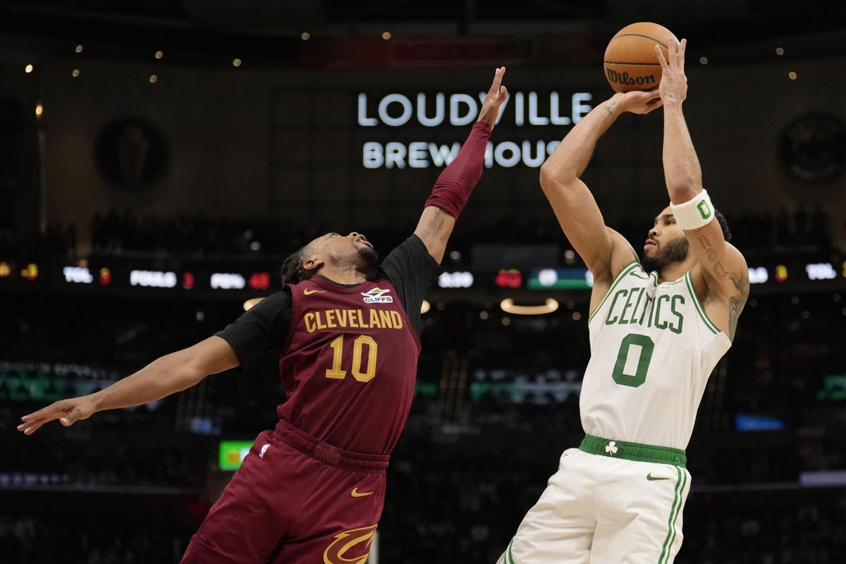 Boston Celtics forward Jayson Tatum (0) shoots as Cleveland Cavaliers guard Darius Garland (10) defends in the second half of an NBA basketball game, Sunday, Dec. 1, 2024, in Cleveland. (AP Photo/Sue Ogrocki)