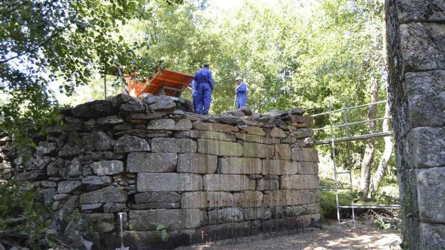 Un grupo de obreros trabaja en la restauración del puente La Ajeda, de Requejo.