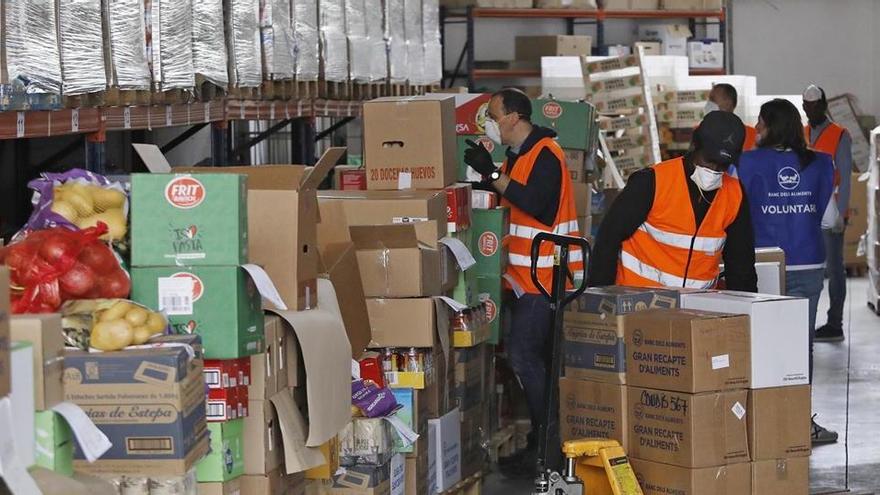 Voluntaris descarregant la donació, ahir al matí, al magatzem del Banc dels Aliments de Girona