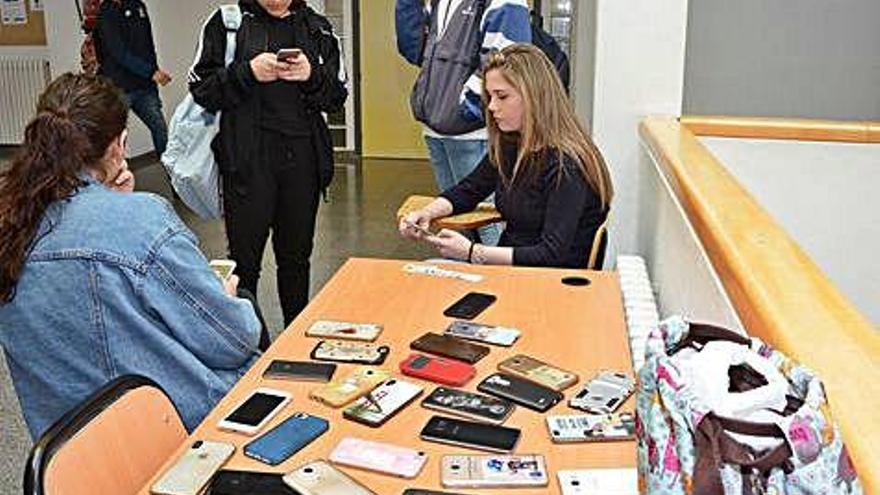 Varias jóvenes recuperan sus móviles tras un examen.