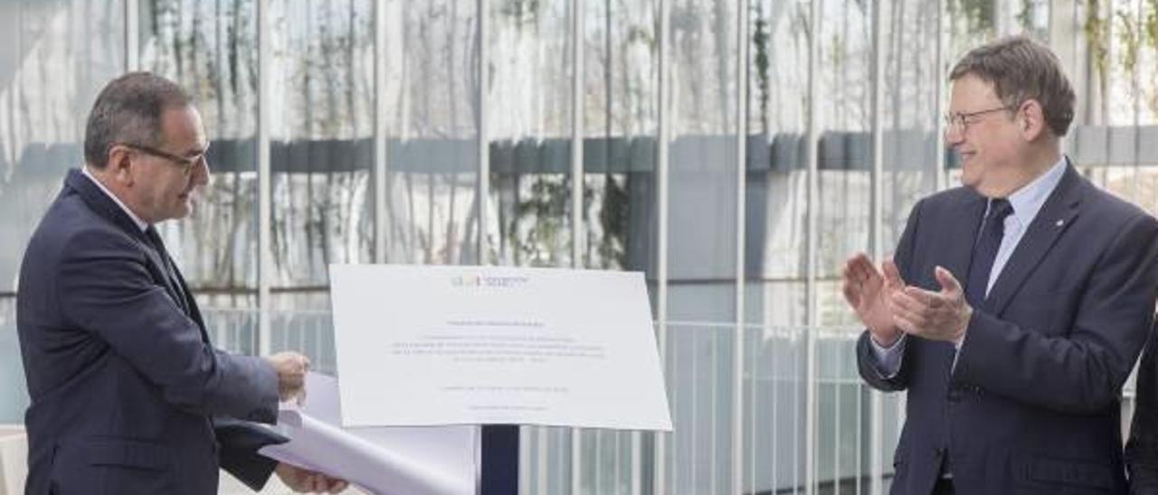 Climent destapa la placa de la inauguración de la Facultad de la Salud mientras le observa el presidente del Consell, Ximo Puig.