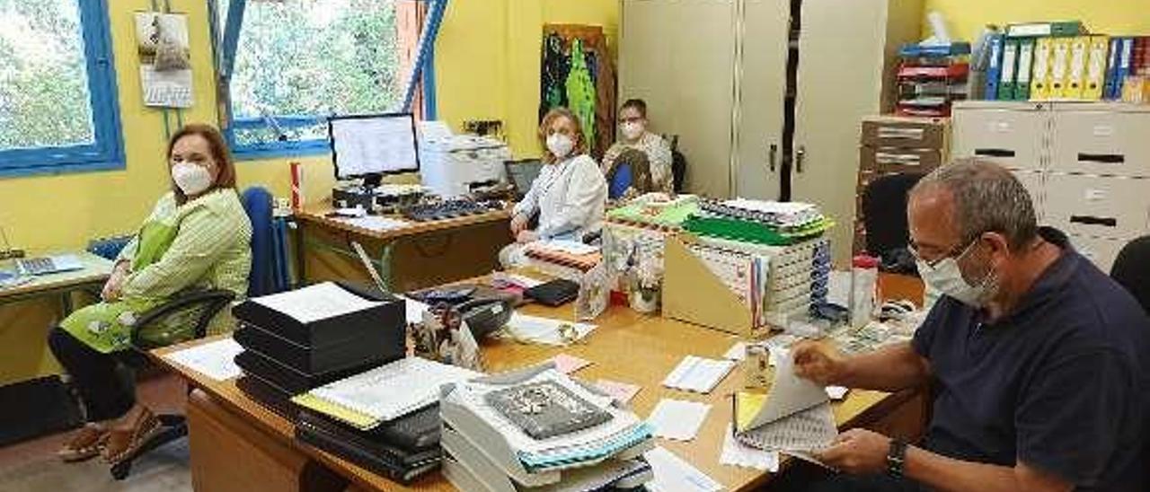 La directora del colegio público Virgen del Fresno de Grado, Paraíso Álvarez; las directivas Carmen Varela y Rosa Soto, y el administrativo, Julio Santamaría, ayer, trabajando en el centro.