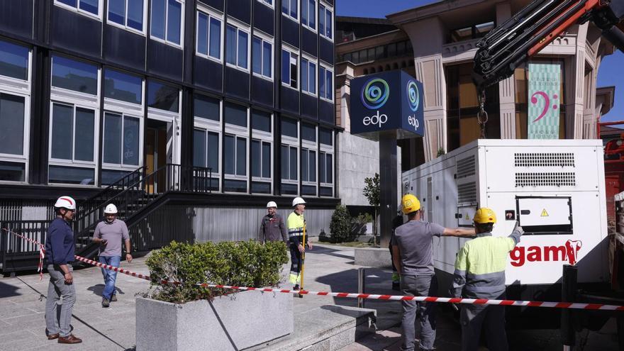 Un grupo de operarios instala un generador autónomo de electricidad en la sede de EDP, en Oviedo. | LUISMA MURIAS