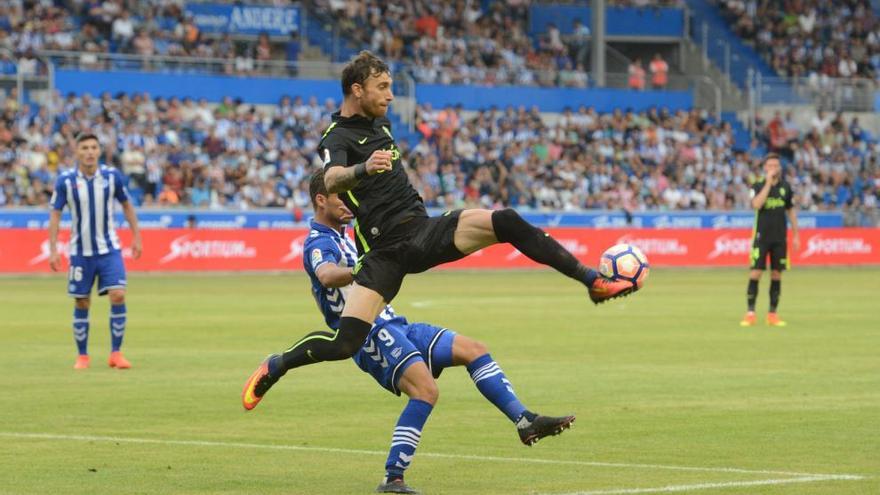 El defensa sportinguista Amorebieta despeja el balón en presencia de Santos, del Alavés, en el partido que los rojiblancos jugaron esta temporada en Vitoria.