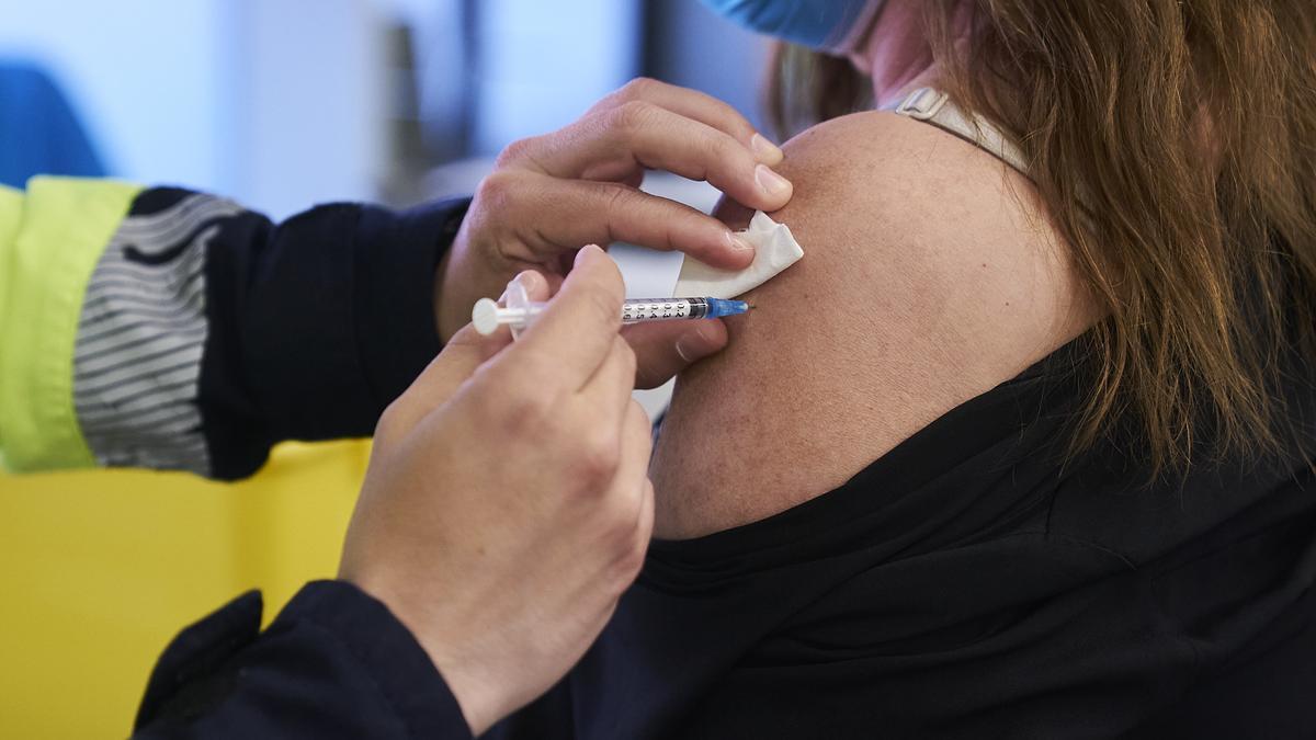 Un sanitario vacuna a una mujer con la dosis de Pfizer.