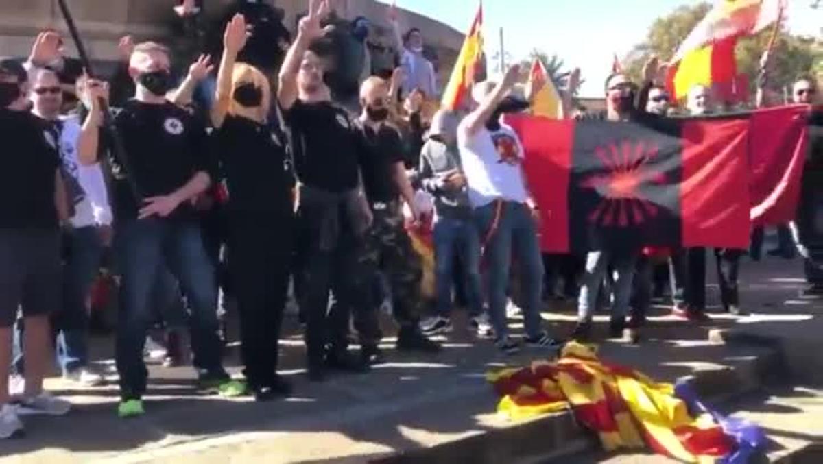 Manifestantes ultras queman una ’estelada’ y cantan el ’Cara al sol’.