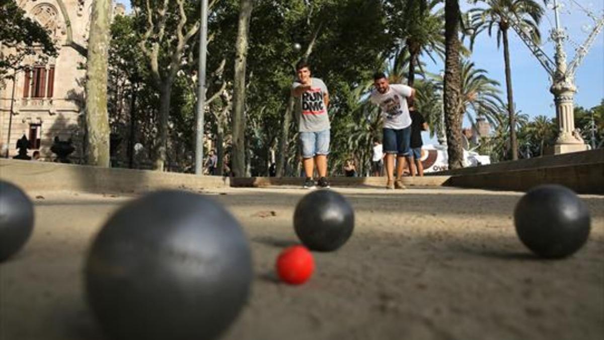 Eric Gámez (izquierda) y Sergi Rodríguez (derecha) lanzan bolas en una pista de petanca situada junto al Arc de Triomf, el pasado día 6.