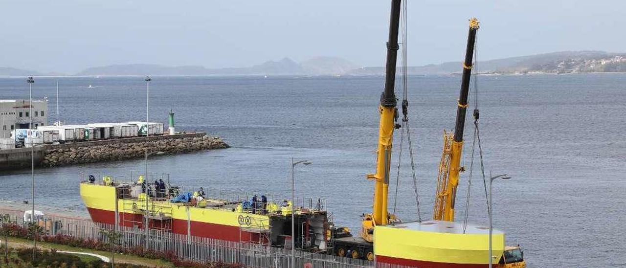 Operarios trabajando ayer con grúas en el ensamblaje del tercer bloque de la plataforma. // Ricardo Grobas