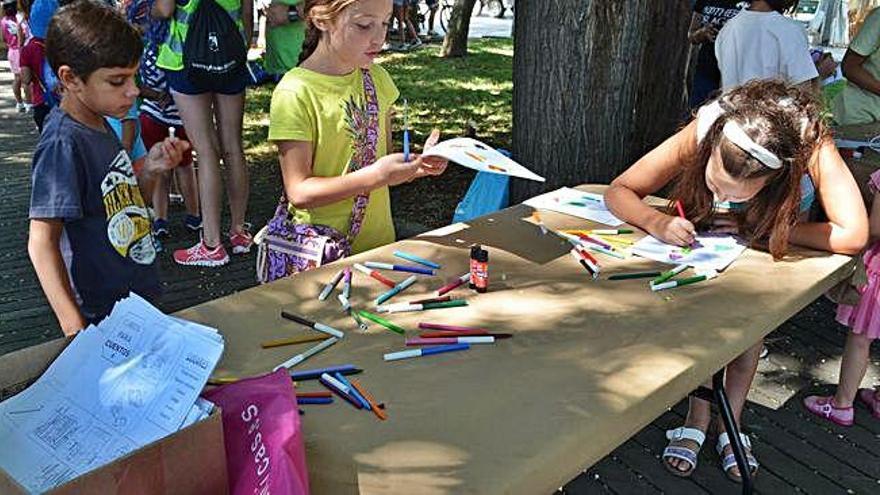 Un grupo de niños pintando los dibujos que ilustrarán más tarde el cubo.