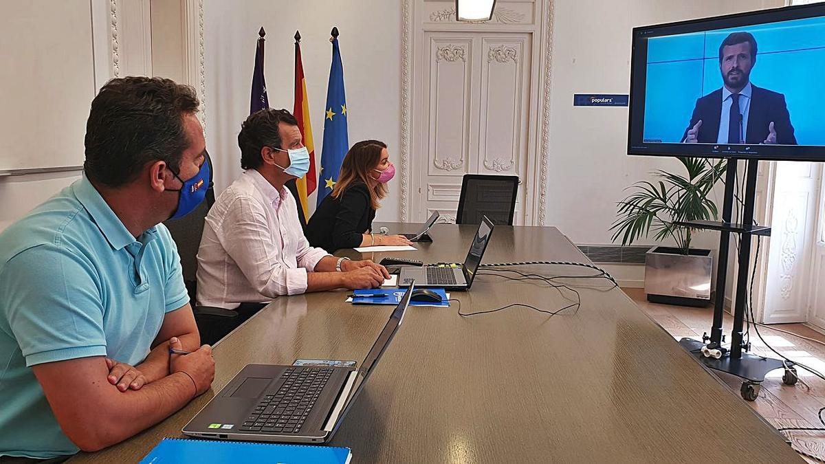 Company, entre Fuster y Prohens, escuchando una intervención telemática de Casado.