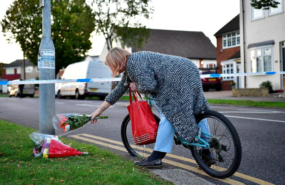 Una persona deja unas flores en el lugar de la muerte de David Amess.