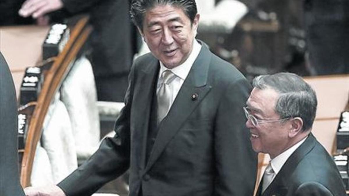 El primer ministro japonés, Shinzo Abe (centro), conversa con el ministro de Economía, Yoichi Miyazawa.