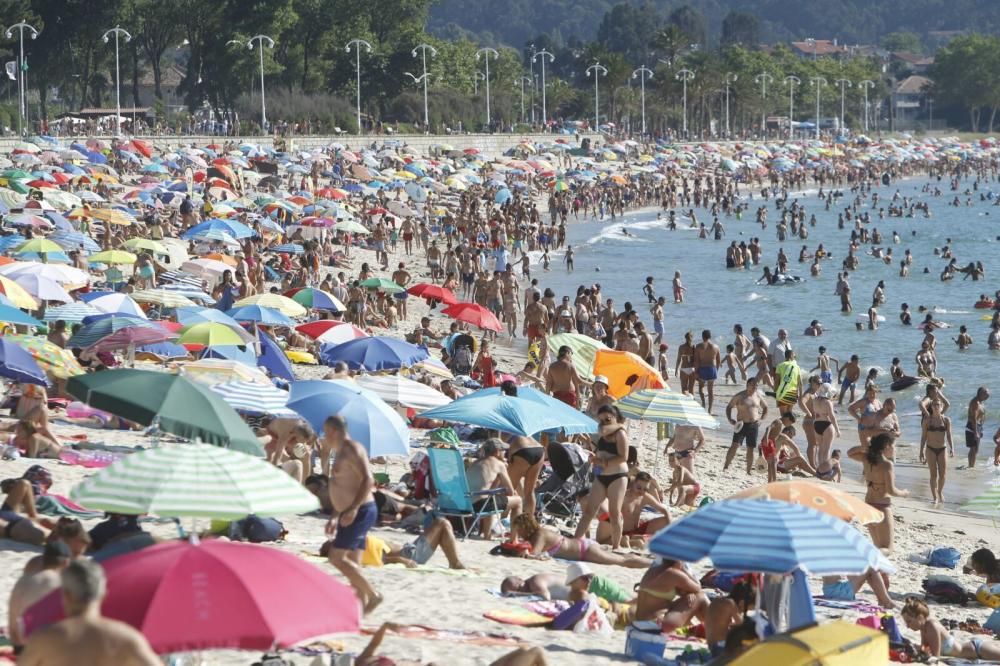 Una plaga de sombrillas irrumpe en Samil durante una jornada muy calurosa en el primer fin de semana de agosto