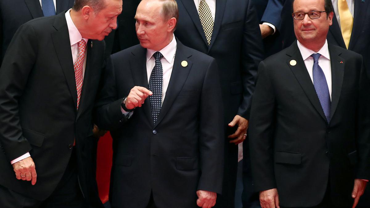 France's President Francois Hollande looks as Russian President Vladimir Putin talks to Turkish President Tayyip Erdogan as leaders pose for a group picture during the G20 Summit in Hangzhou